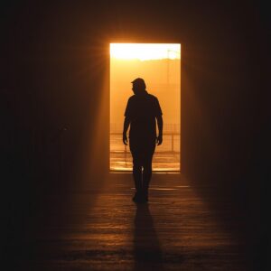 Woman standing at the edge of light reflecting on repeating life patterns